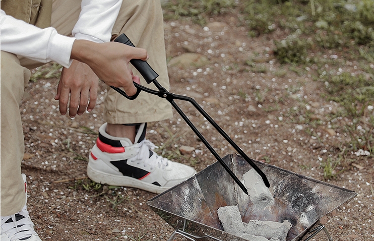 using tongs to catch charcoal